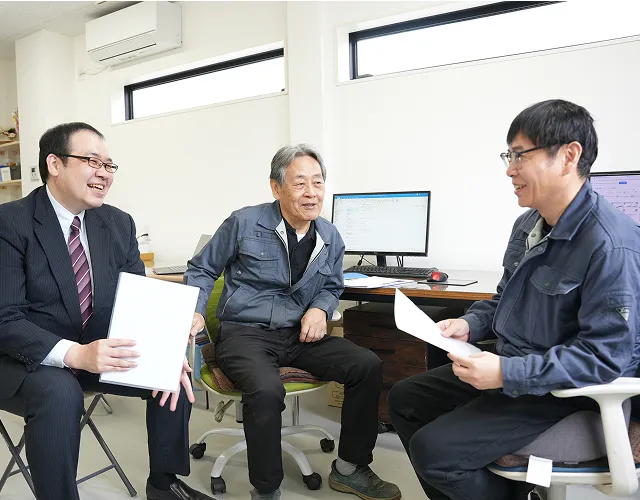 顧客と笑顔で打ち合わせをする担当者